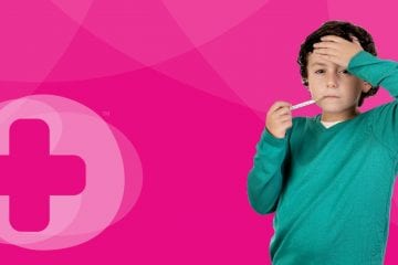 A child wearing a green sweater with a thermometer in his mouth in front of a Skillbase first aid banner
