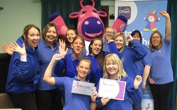 Playschool staff pose with certificates.