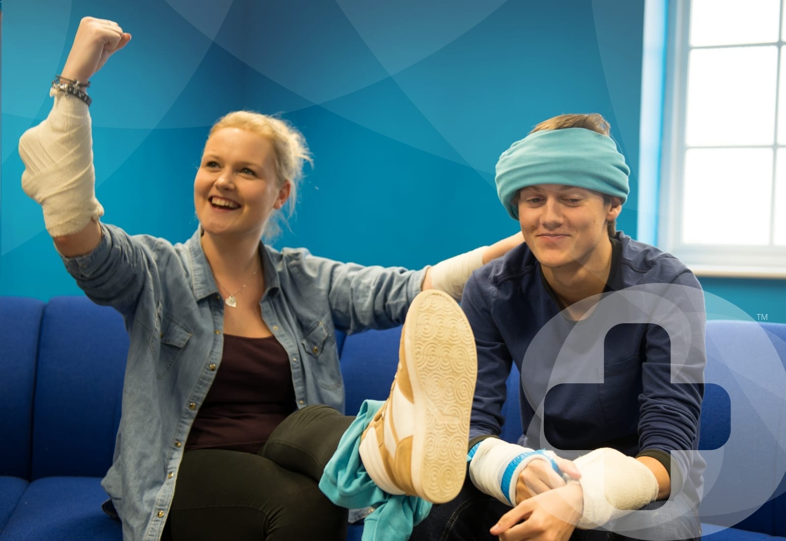 A man and a woman sat down with bandages on their arm, leg and head.