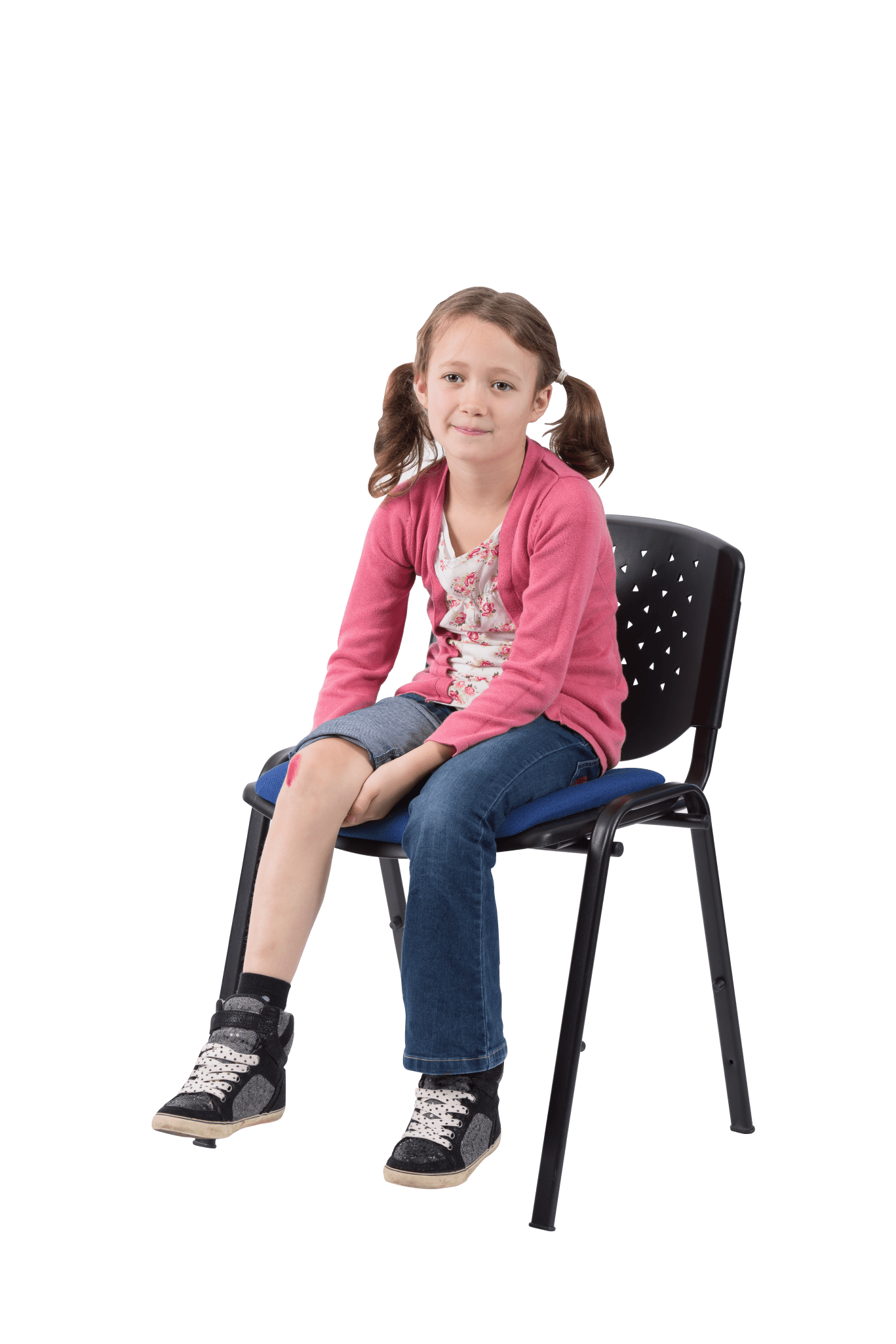 a small girl sits on a chair with her right trouser leg rolled up. She has a cut on her right knee