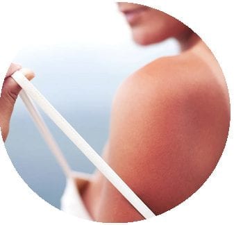 A lady pulling down her vest top strap off of her shoulder.