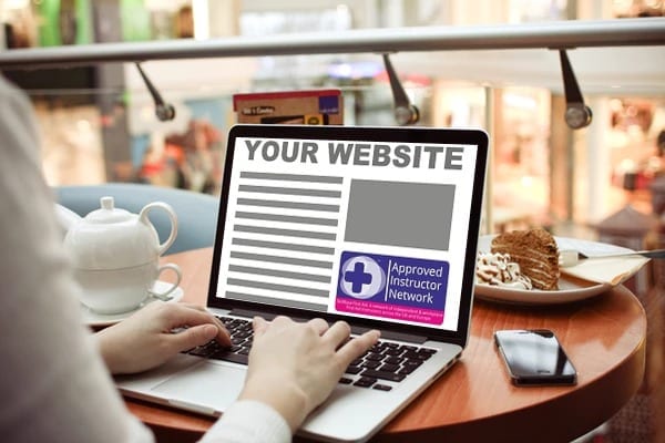 A woman typing on a laptop in a coffee shop with skillbase logo on the screen.