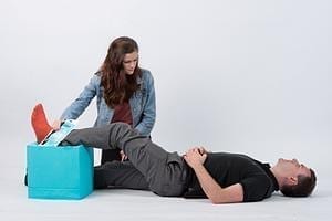man with leg elevated being helped by a woman