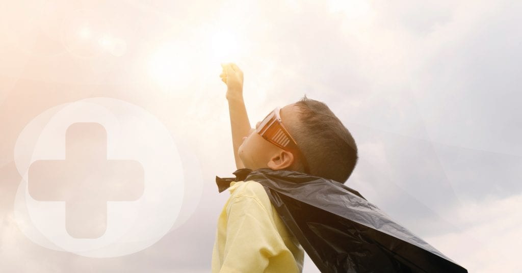 A small child with a cape made from a bin liner looking up at the sun.