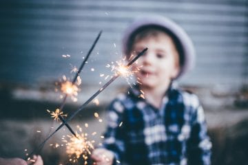 A child playing with sparklers outside